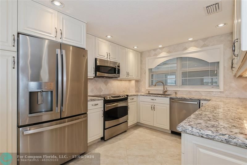 a kitchen with granite countertop stainless steel appliances and counter space