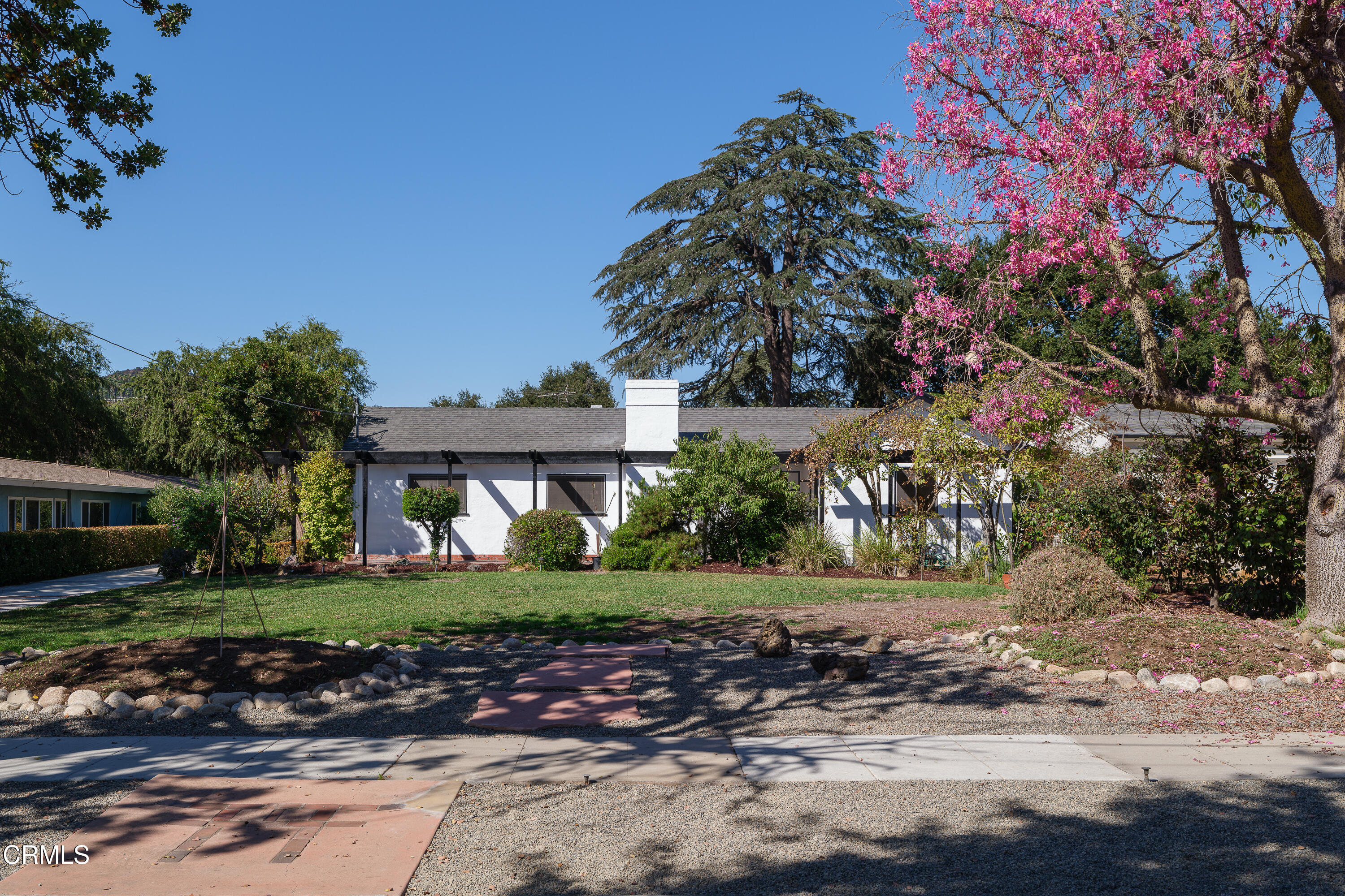 a front view of a house with a yard and potted plants