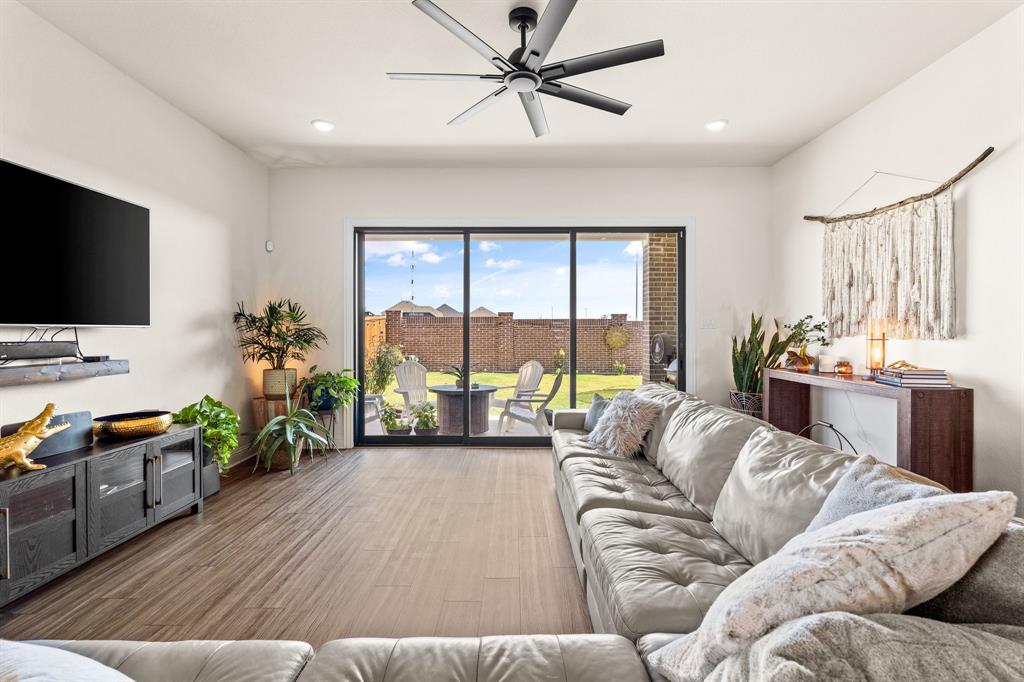 a living room with furniture and a flat screen tv with wooden floor