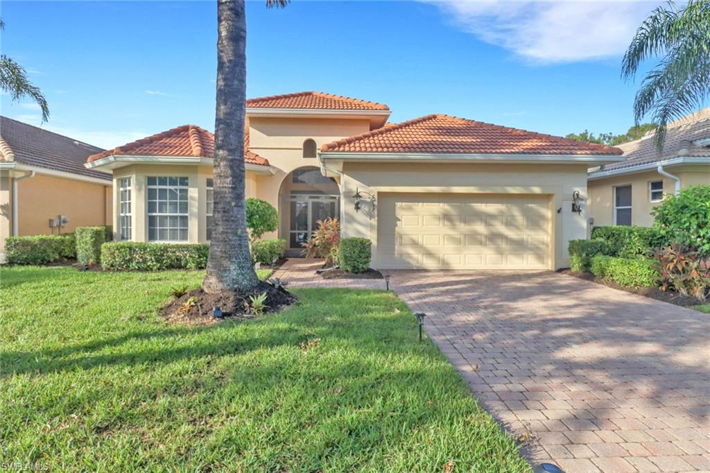 Mediterranean / spanish-style house with a garage and a front lawn