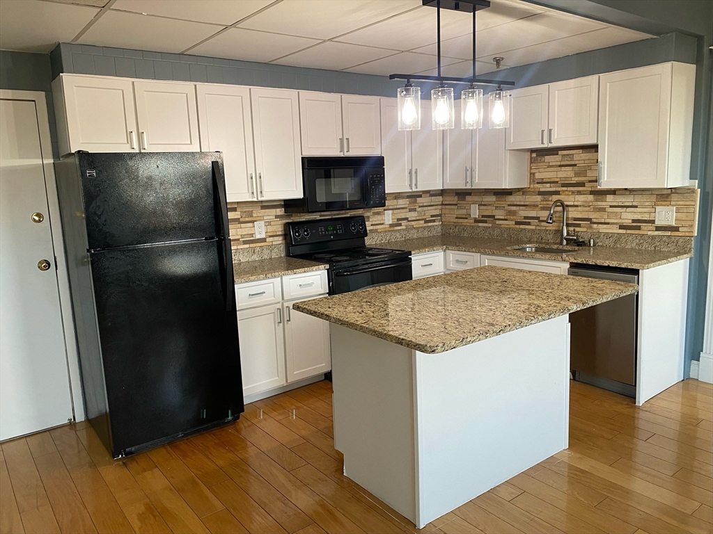 a kitchen with a sink a microwave a refrigerator and cabinets