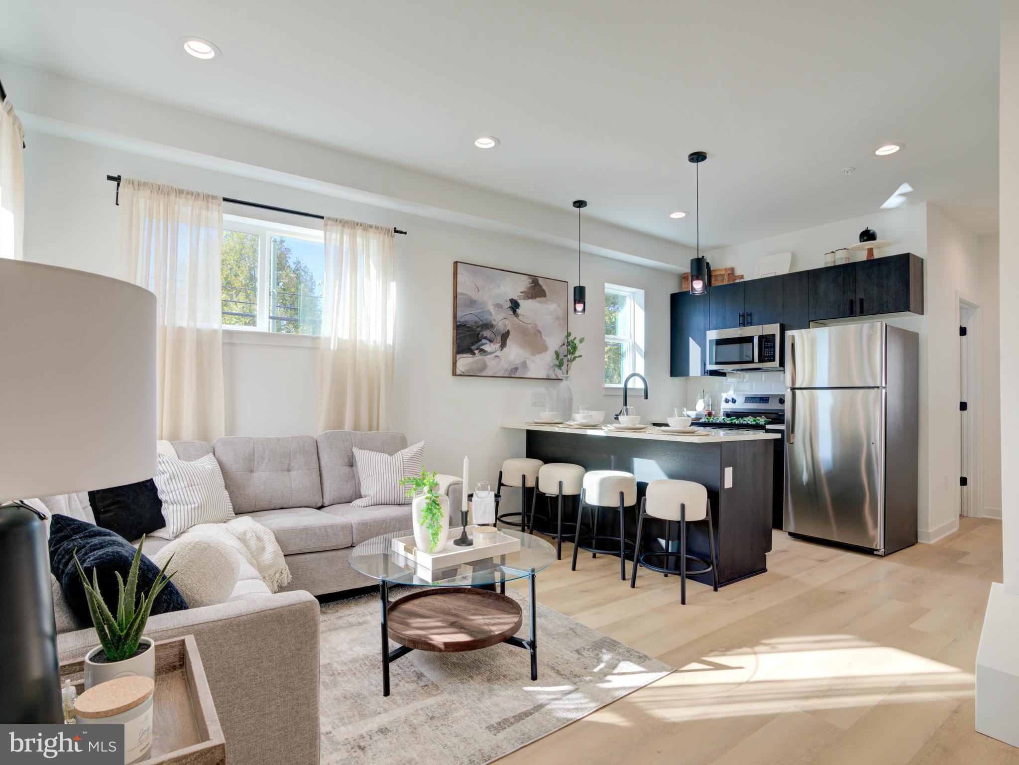 a living room with furniture a refrigerator and kitchen view