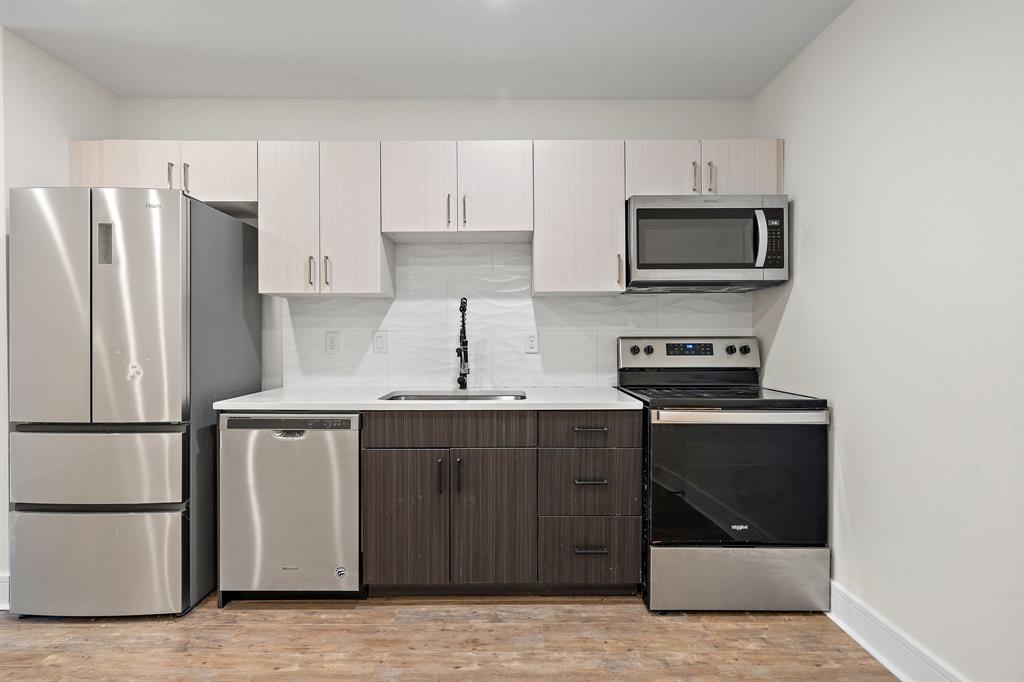 a kitchen with stainless steel appliances a refrigerator stove and microwave