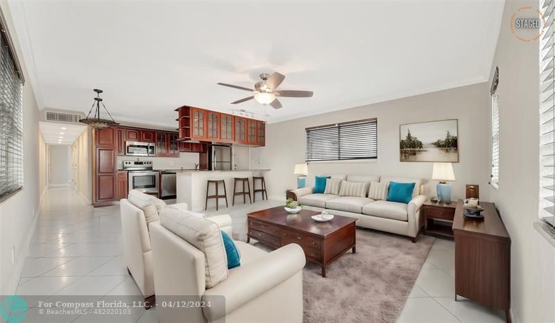 a living room with furniture kitchen view and a chandelier