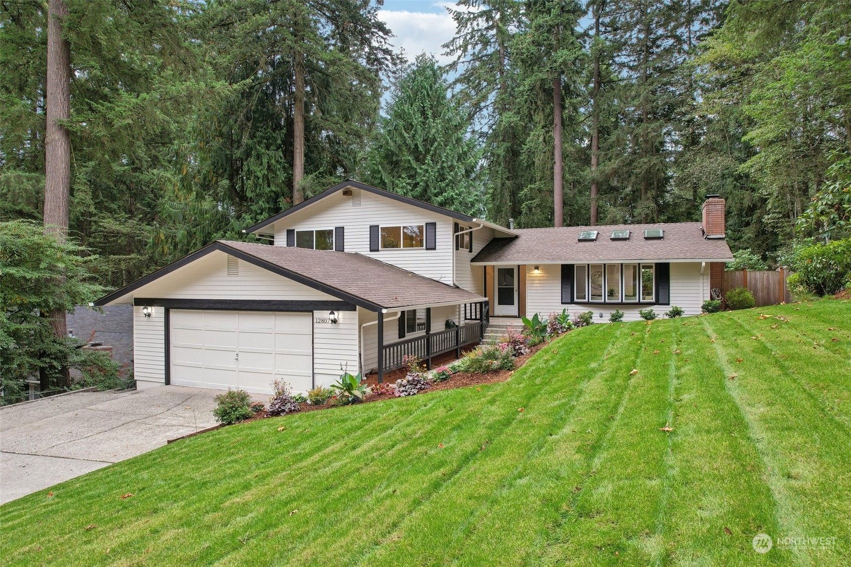 a front view of a house with a yard and trees