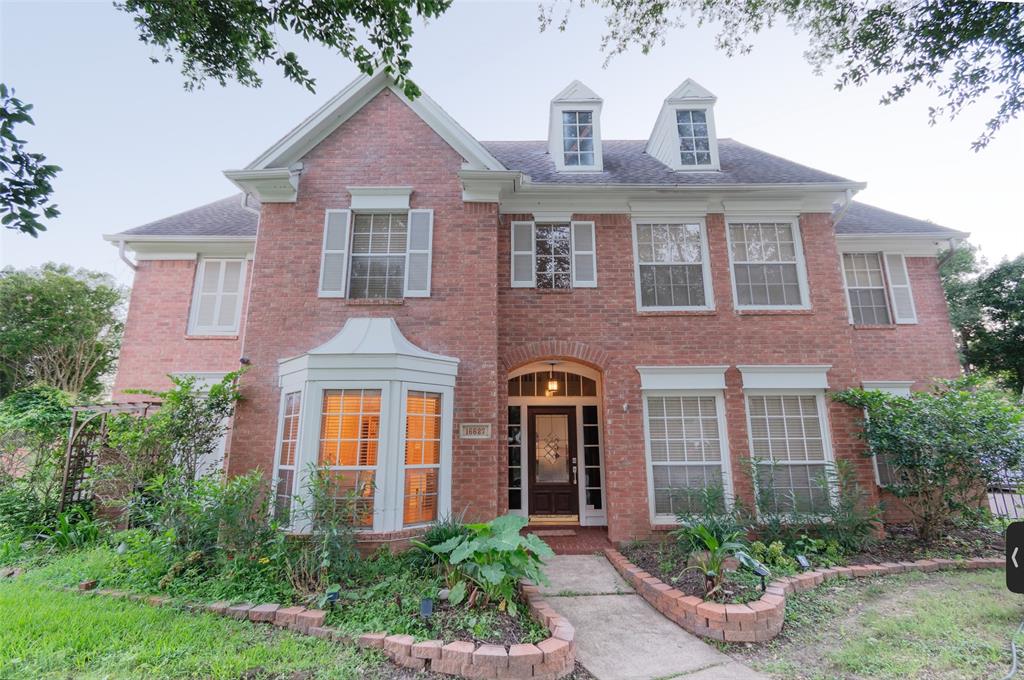 front view of a brick house with a yard