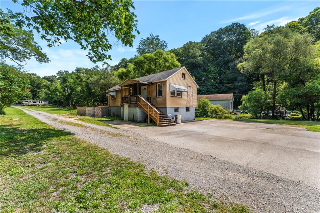 a view of a house with backyard and tree s