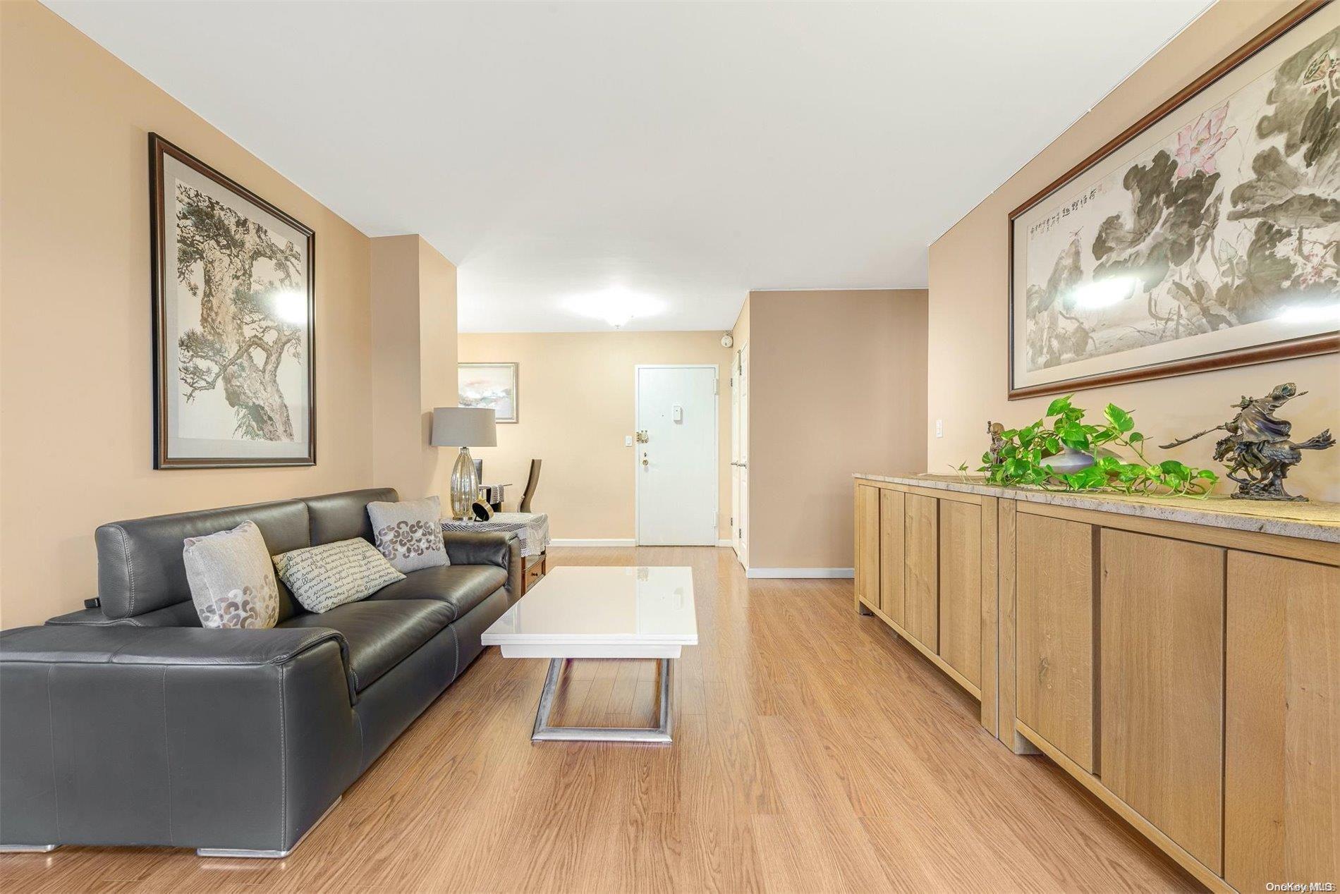 a living room with furniture and a large window with wooden floor