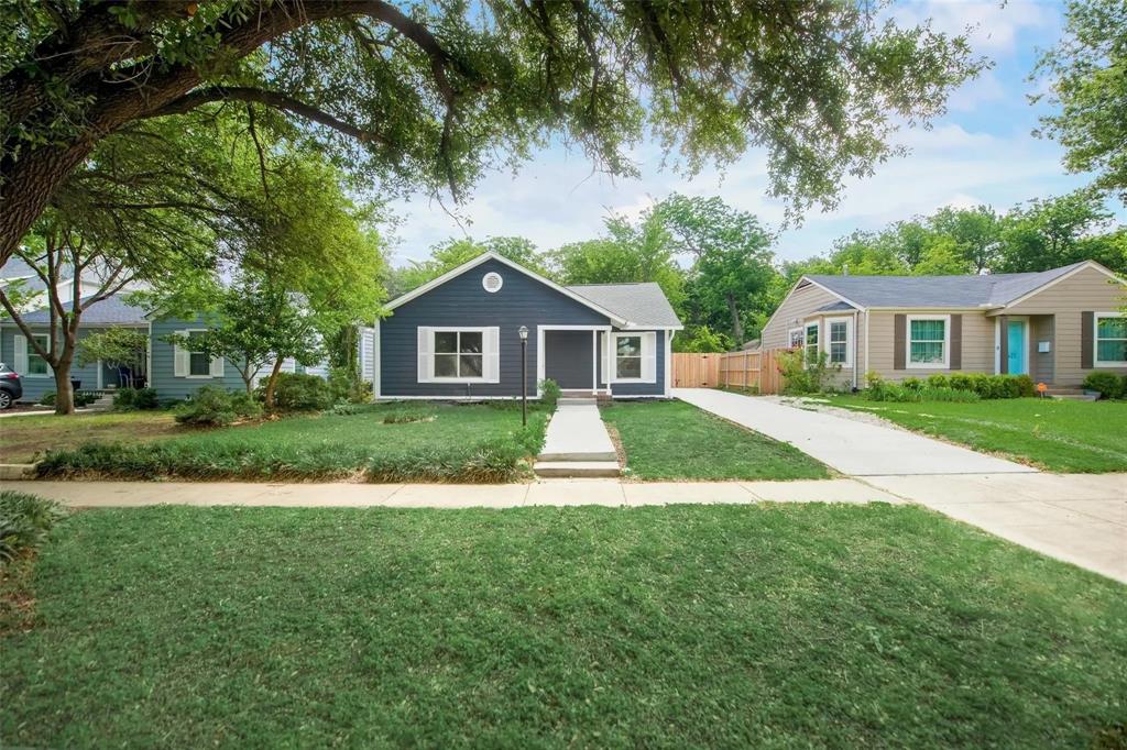 a front view of a house with a yard and green space