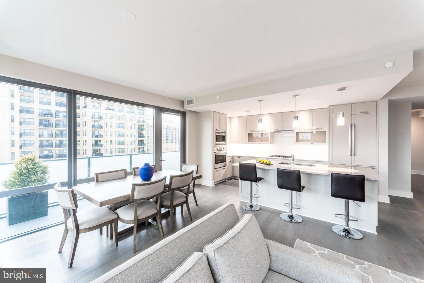 a living room with furniture and floor to ceiling windows