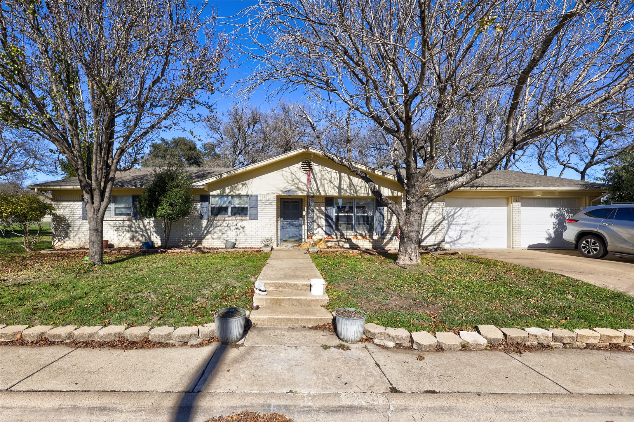 a front view of a house with a yard and a garden