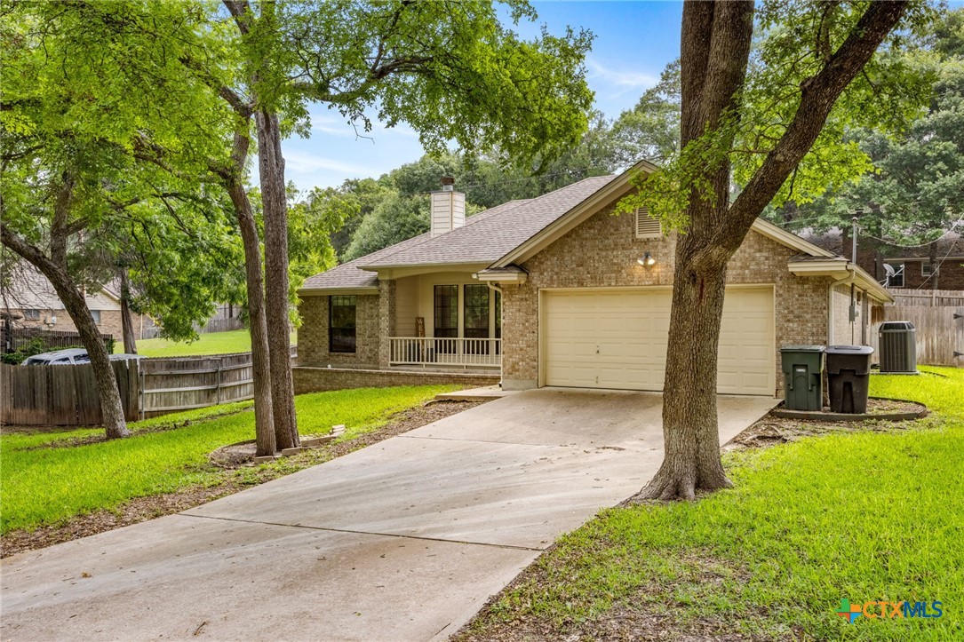 a view of a house with a big yard plants and large trees