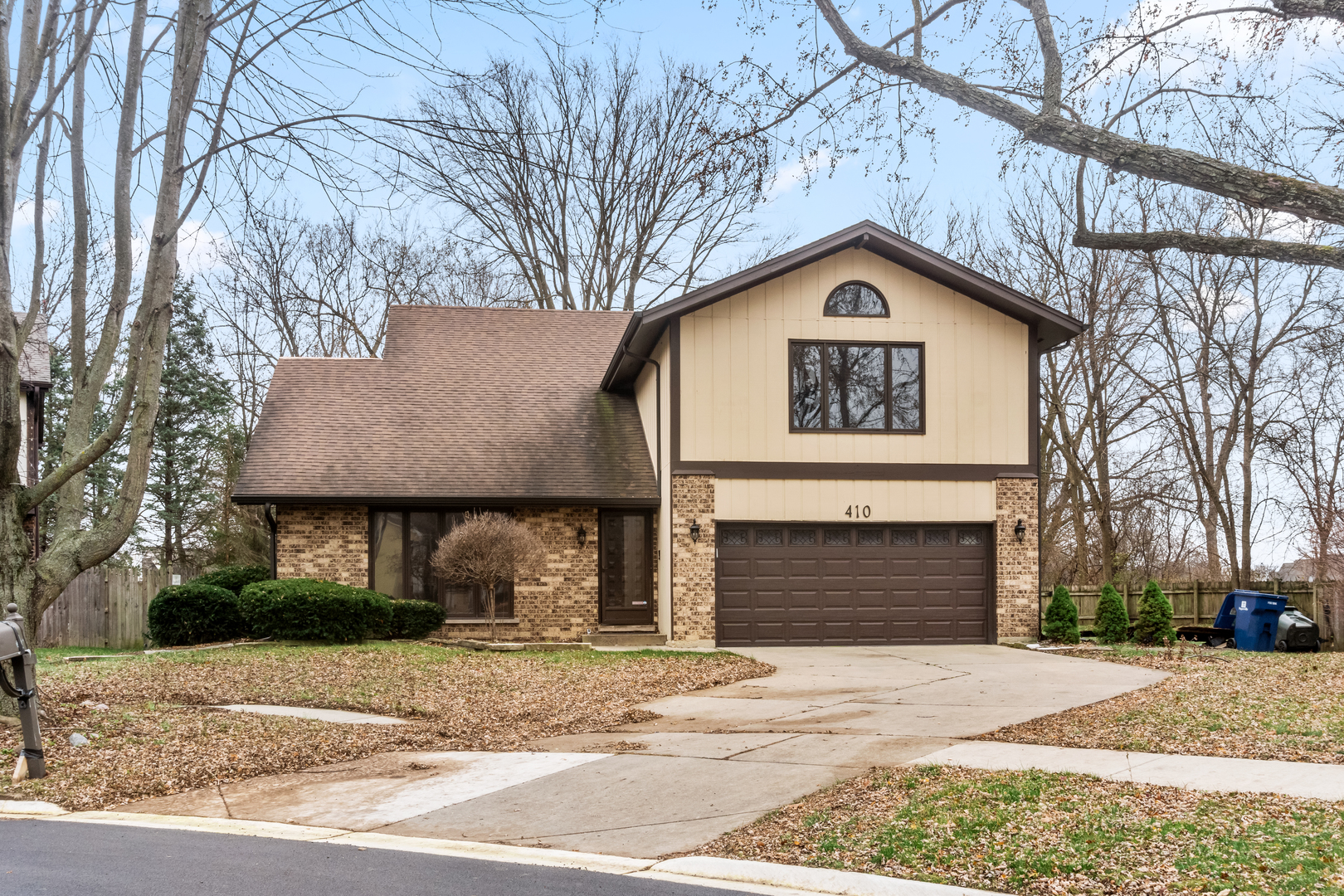 a front view of a house with yard and parking