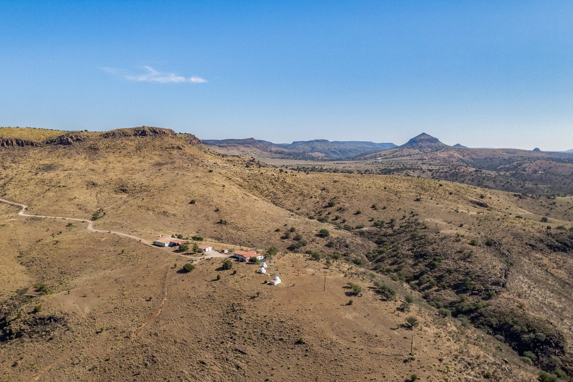 a view of a dry yard with mountains in the background