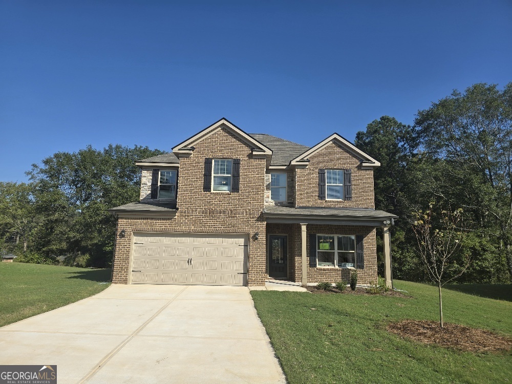 a front view of a house with a garden and yard