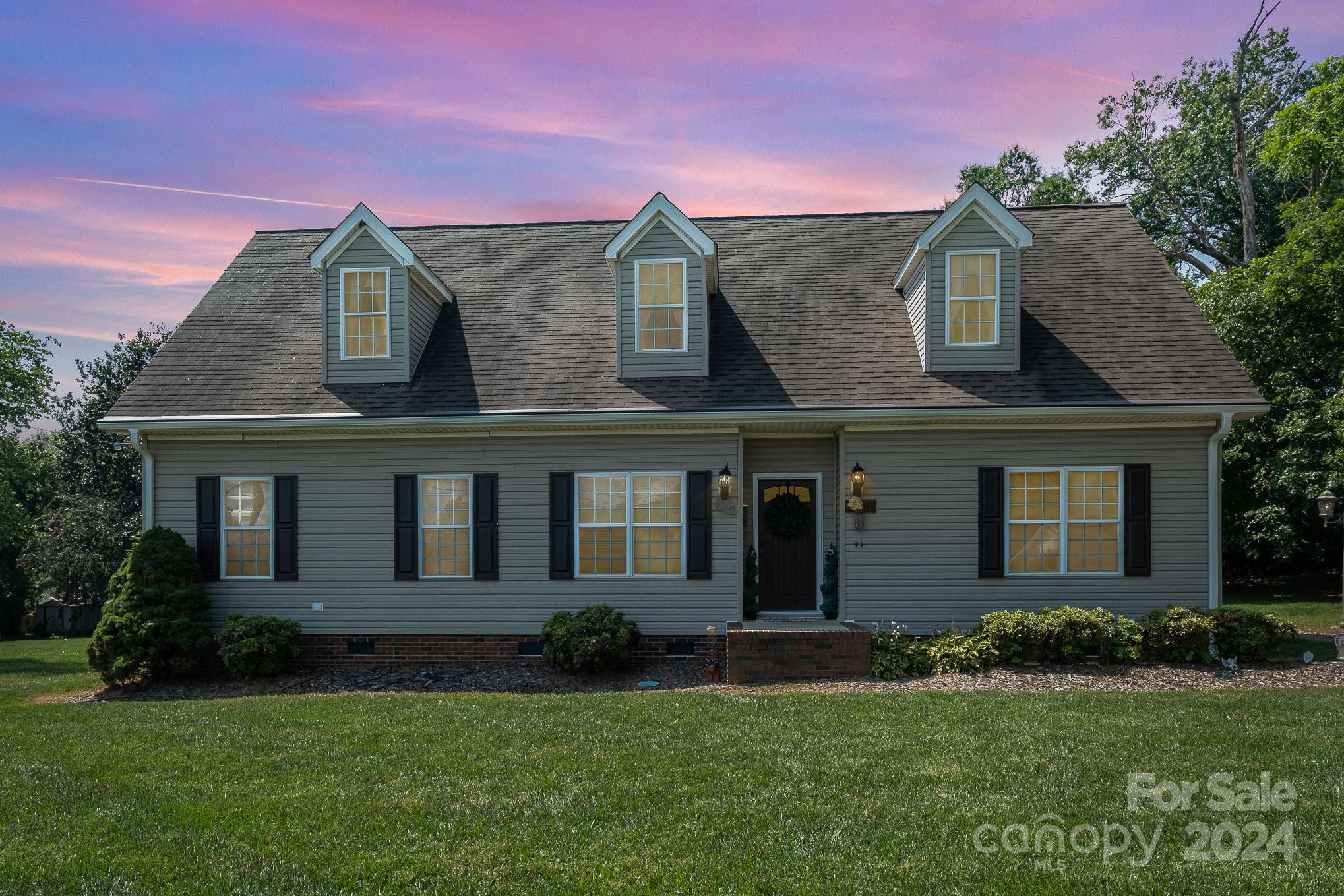 a front view of a house with a garden