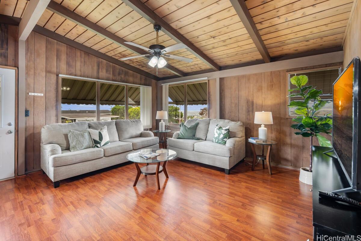 a living room with furniture a wooden floor and next to a window