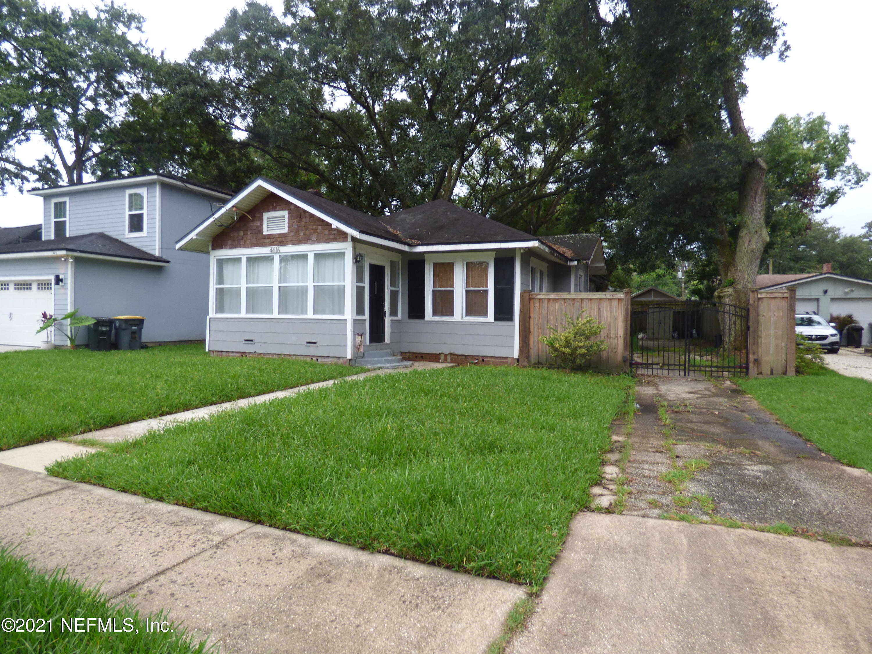 a front view of a house with a yard and trees