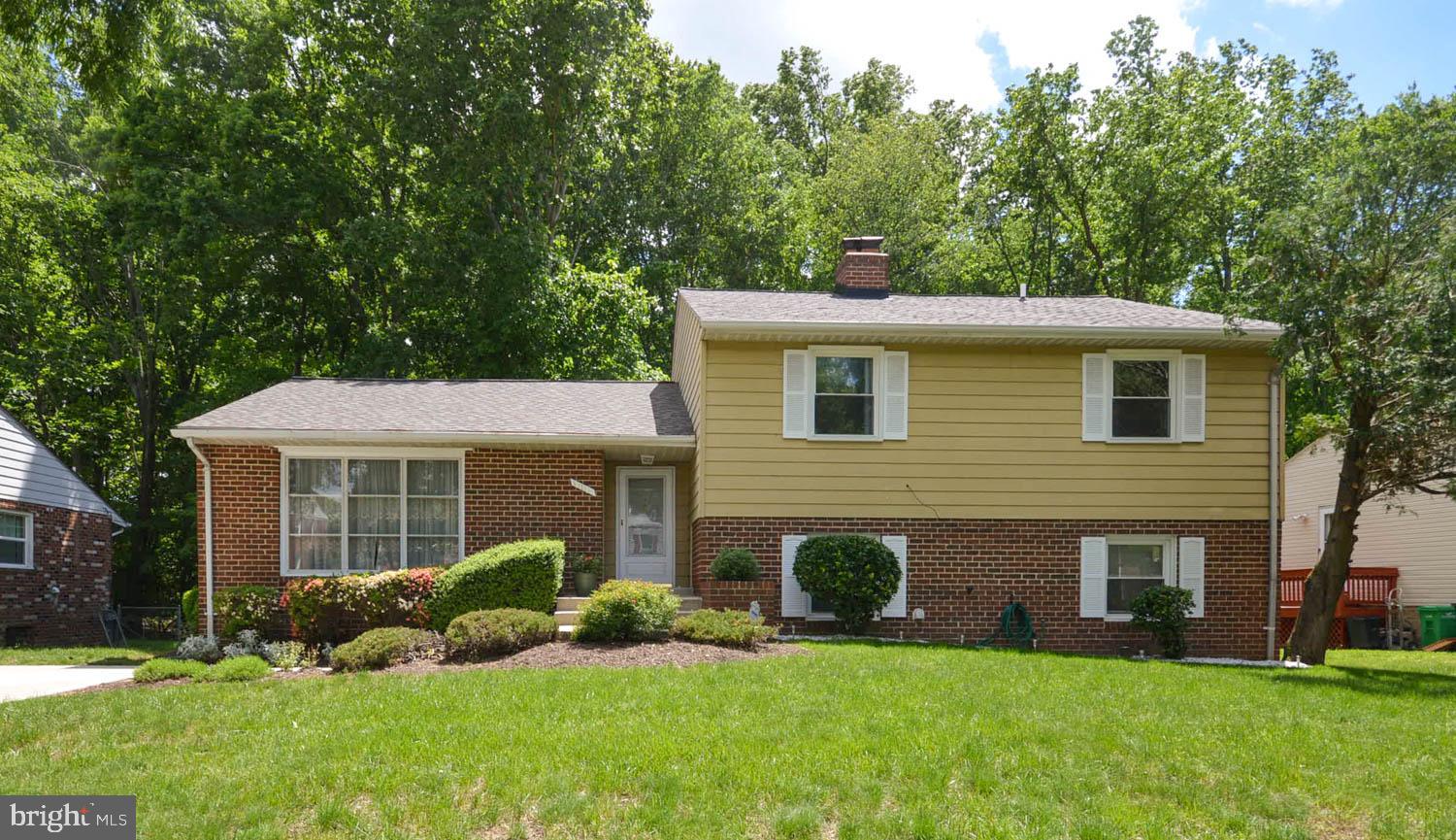 a front view of a house with a yard and trees