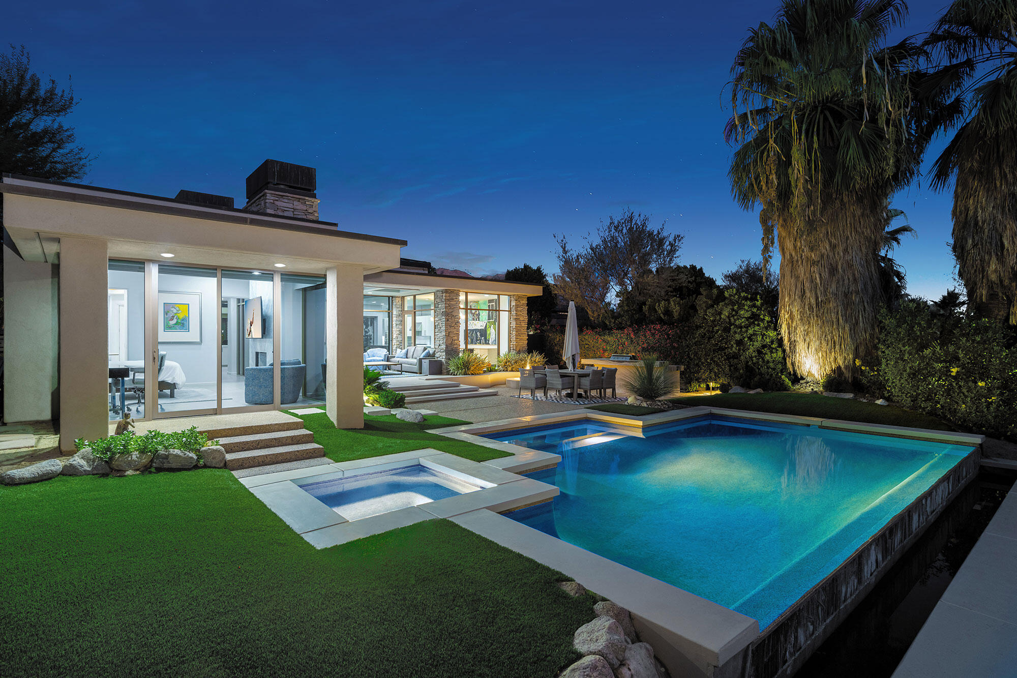 a view of swimming pool with lawn chairs and a yard