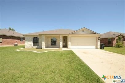 a front view of a house with a garden and yard