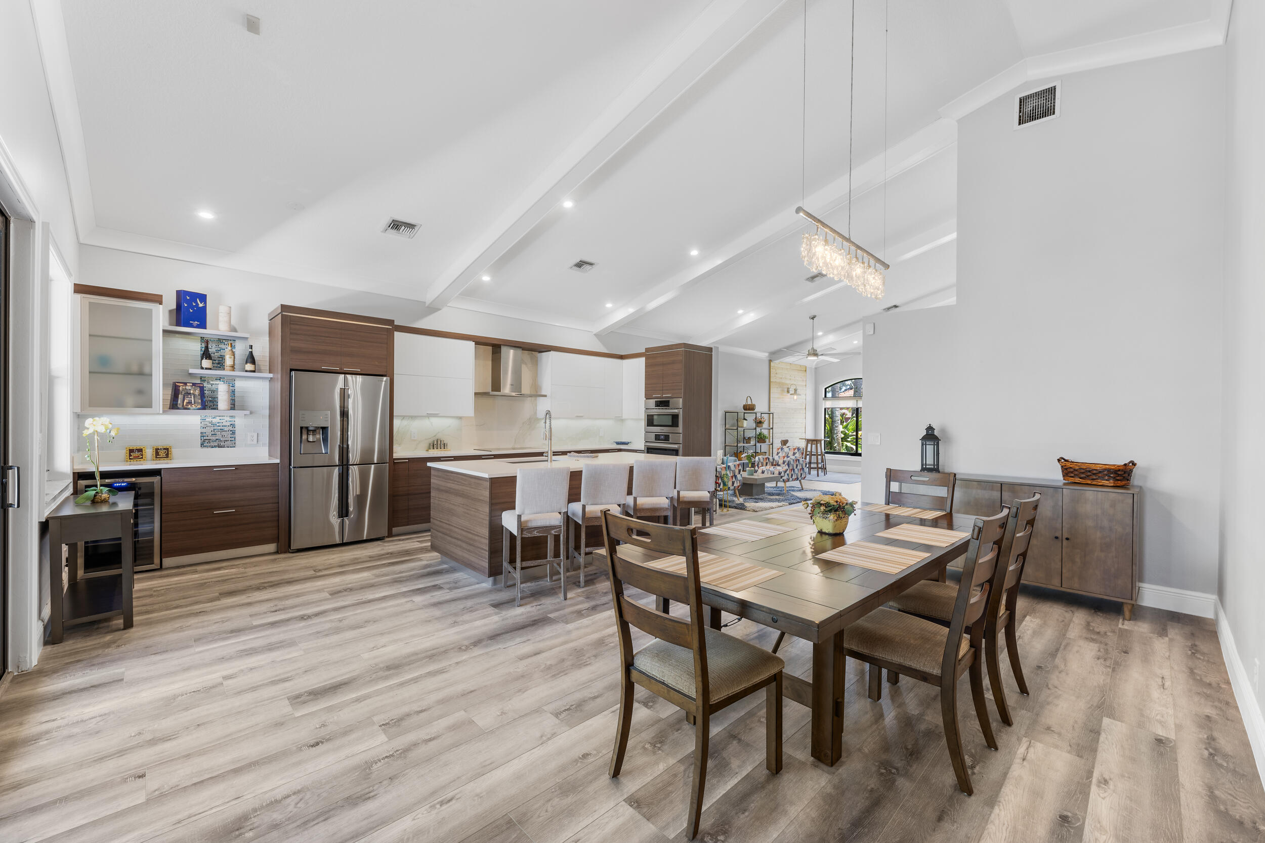 a kitchen with stainless steel appliances kitchen island granite countertop a table chairs and a refrigerator