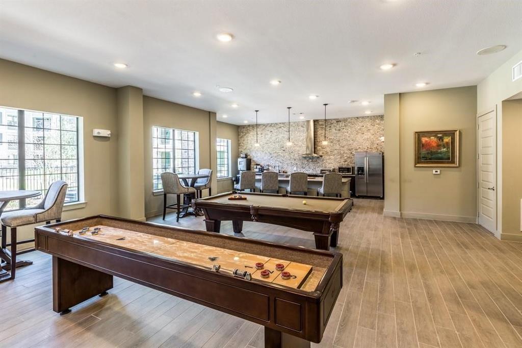 a living room with stainless steel appliances kitchen island granite countertop furniture and a wooden floor