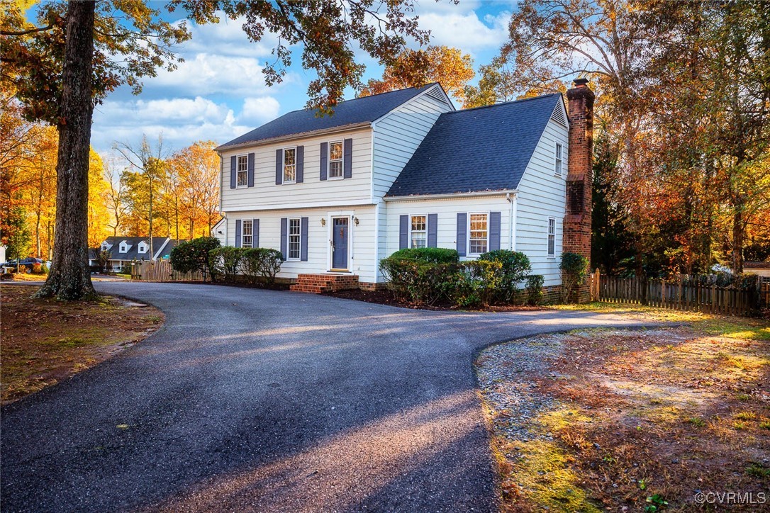 a front view of house with yard and trees around