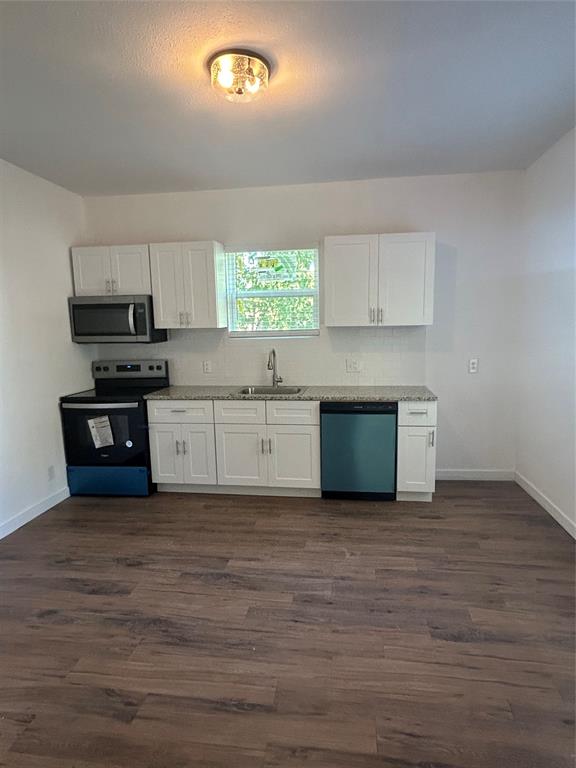 a kitchen with stainless steel appliances a stove a sink and a microwave