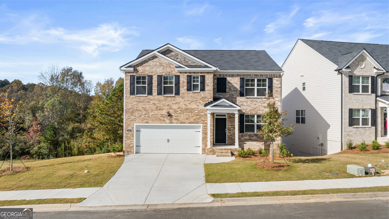 a front view of a house with a yard and garage