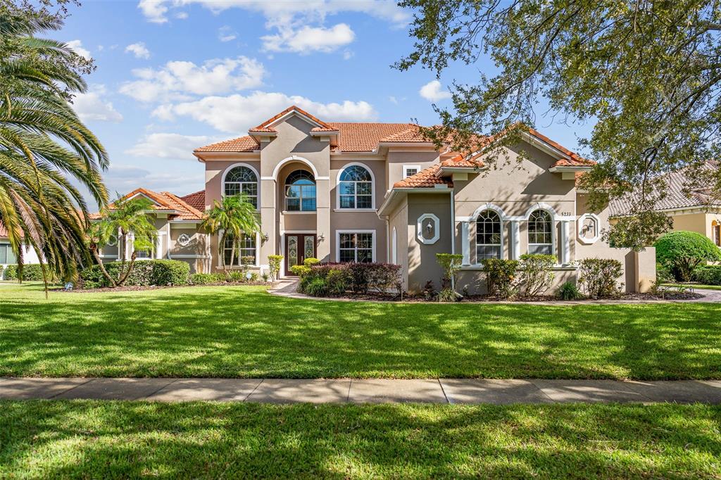 a view of a house with a big yard and large trees