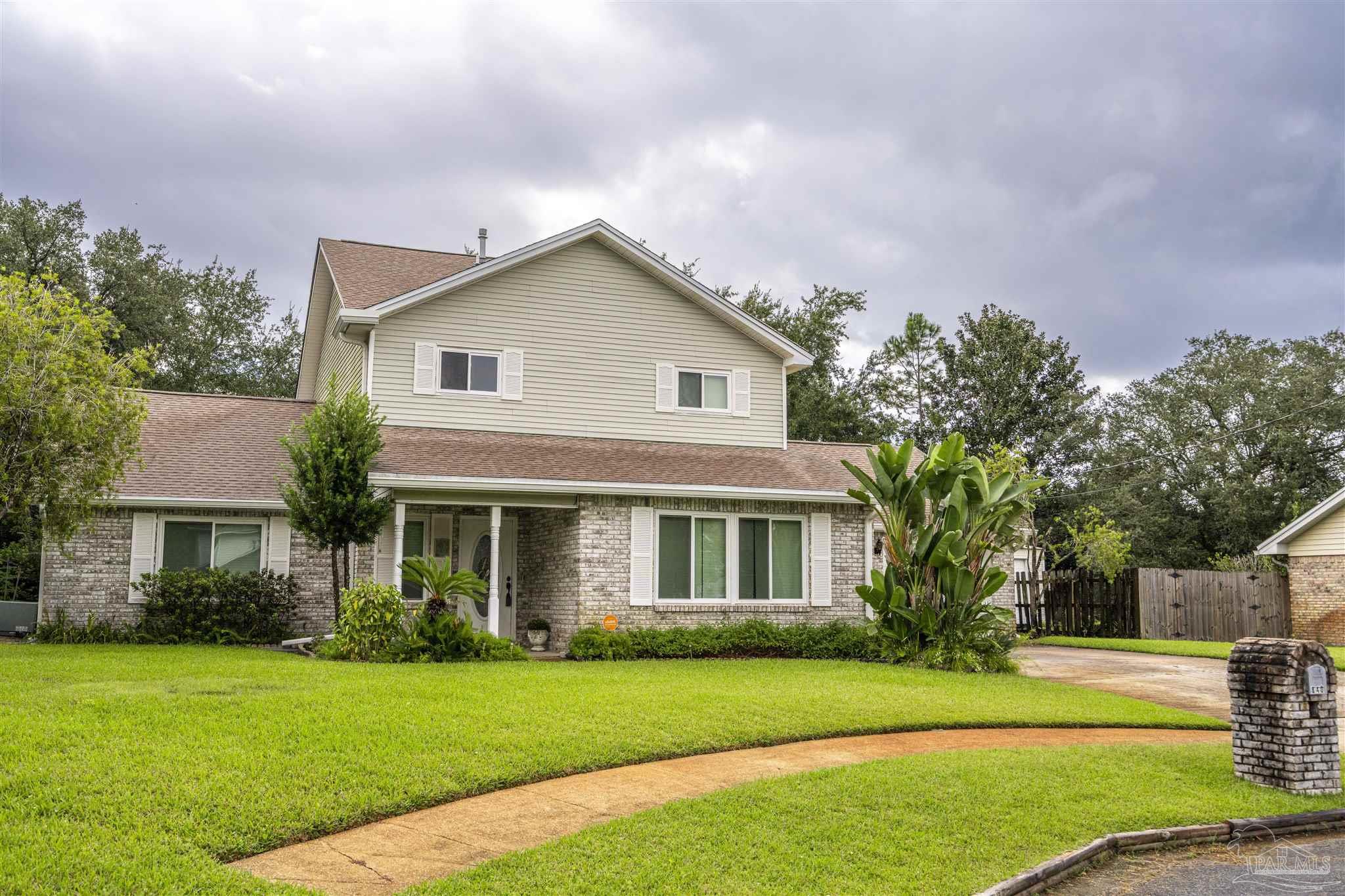 a front view of a house with a yard and trees