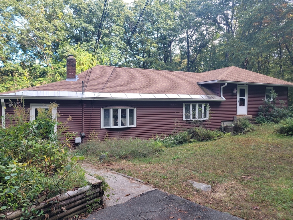 a front view of a house with yard and tree