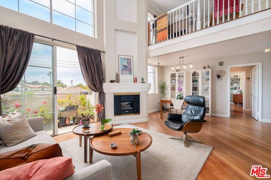 a living room with furniture a fireplace and floor to ceiling windows