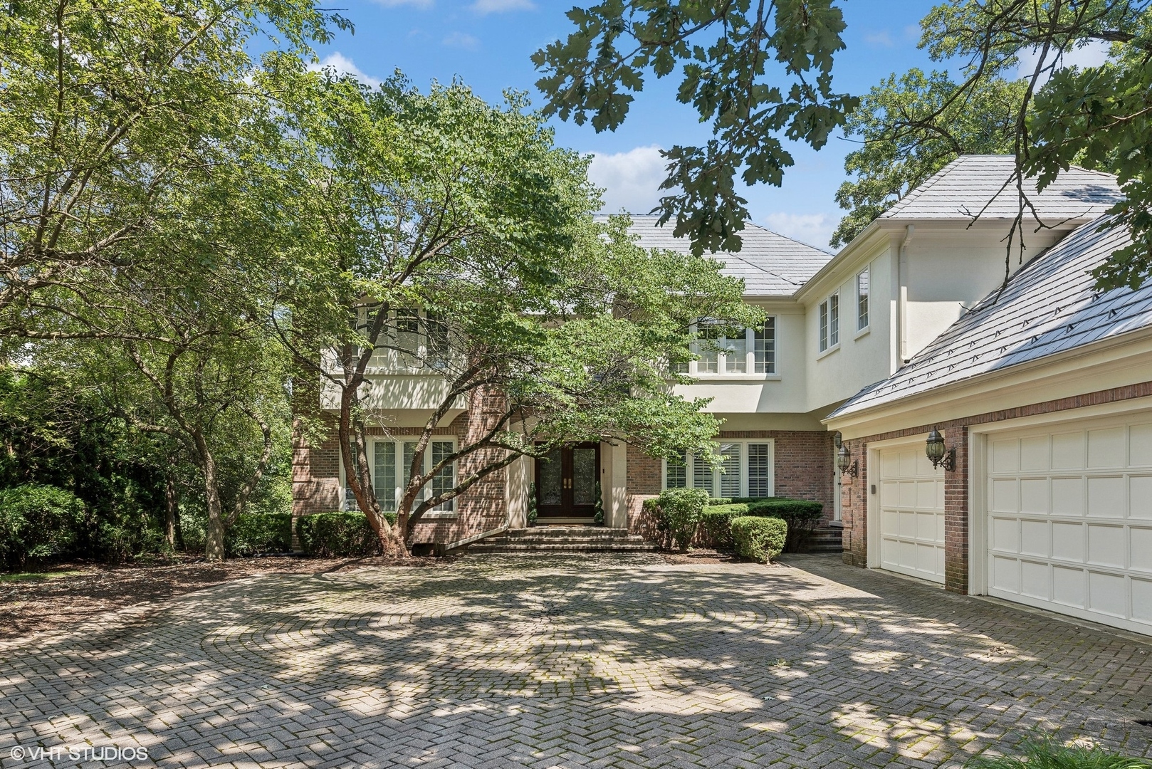 a front view of a house with a tree