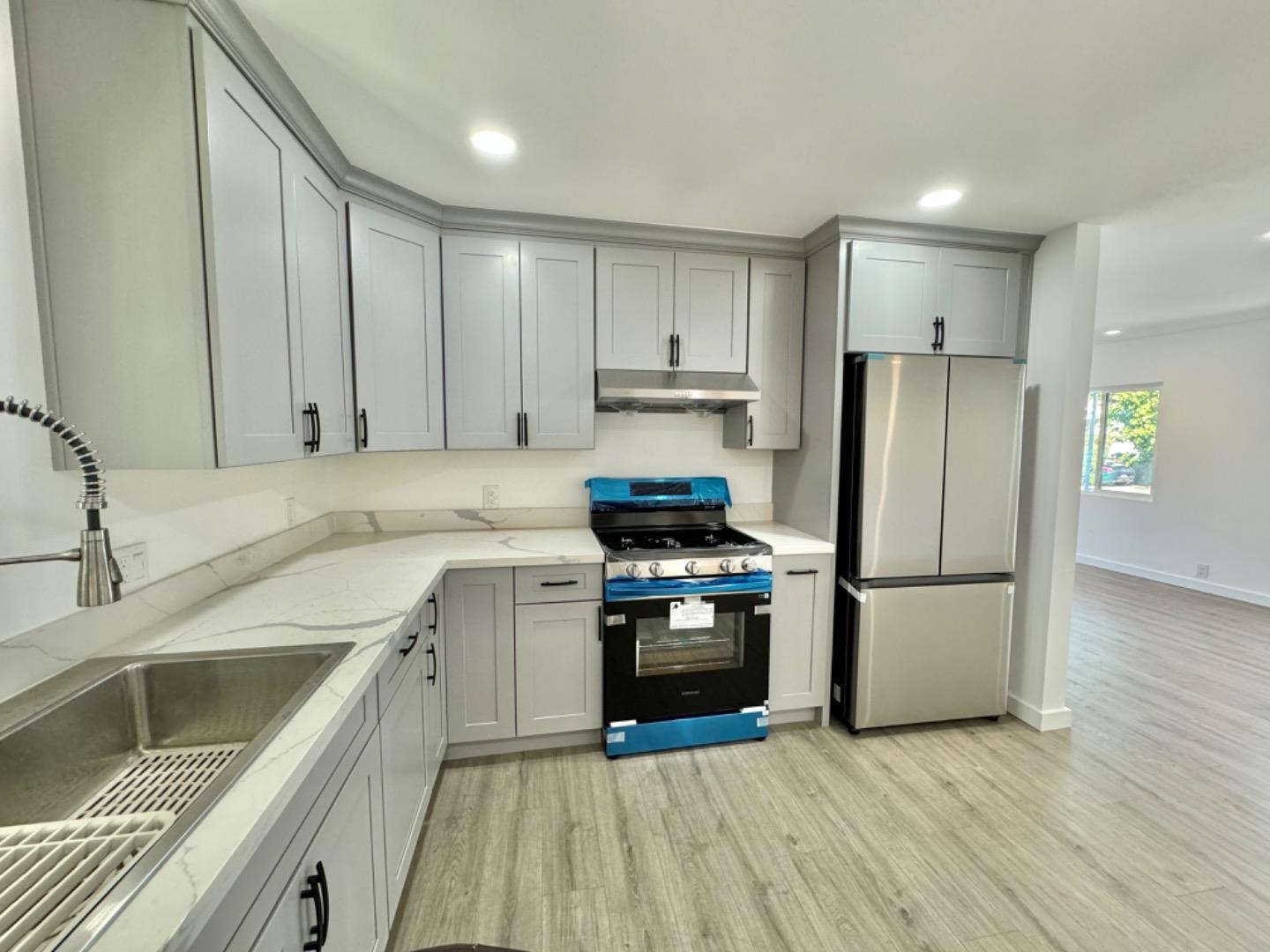 a kitchen with a sink a refrigerator and a stove top oven