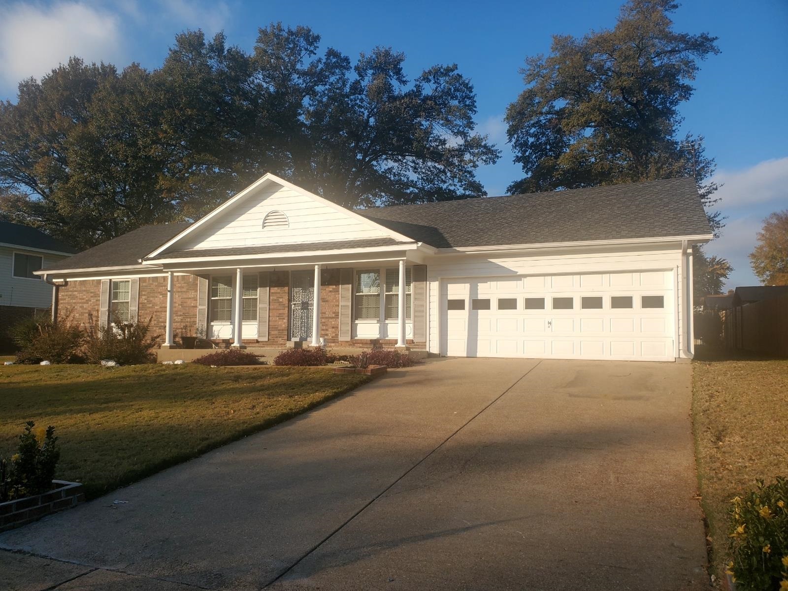 View of front facade with covered porch, a garage, and a front lawn