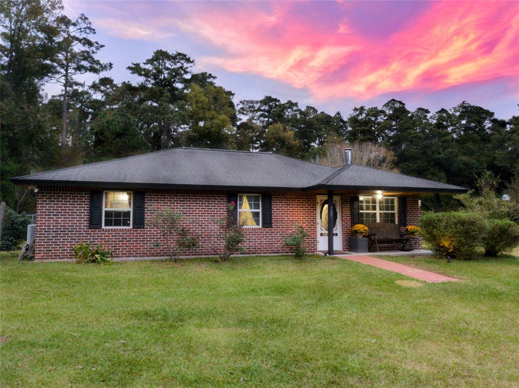 a front view of a house with a yard and trees