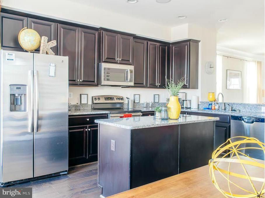 a kitchen with a sink refrigerator and cabinets