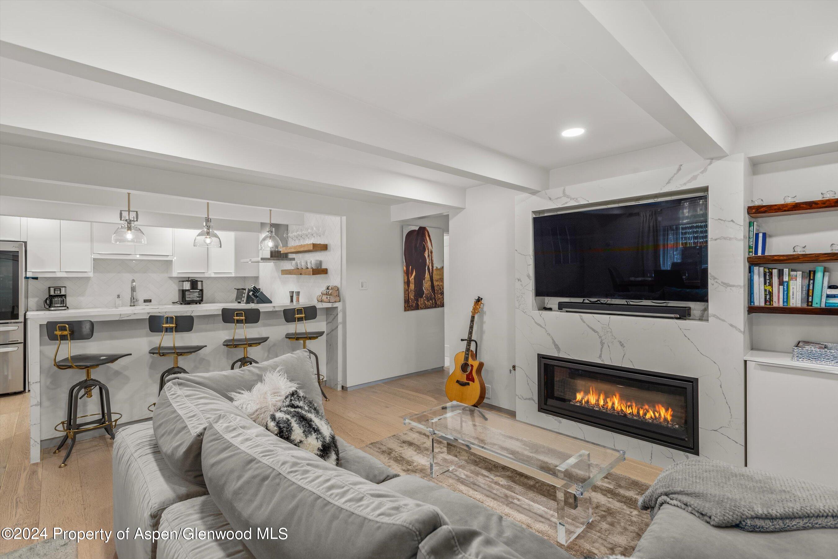 a living room with furniture a flat screen tv and a fireplace