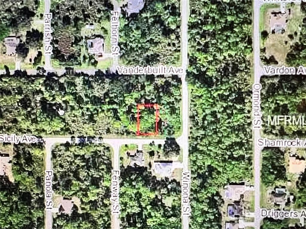 an aerial view of residential houses with outdoor space and trees