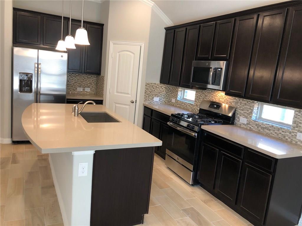 a kitchen with stainless steel appliances a sink and a microwave