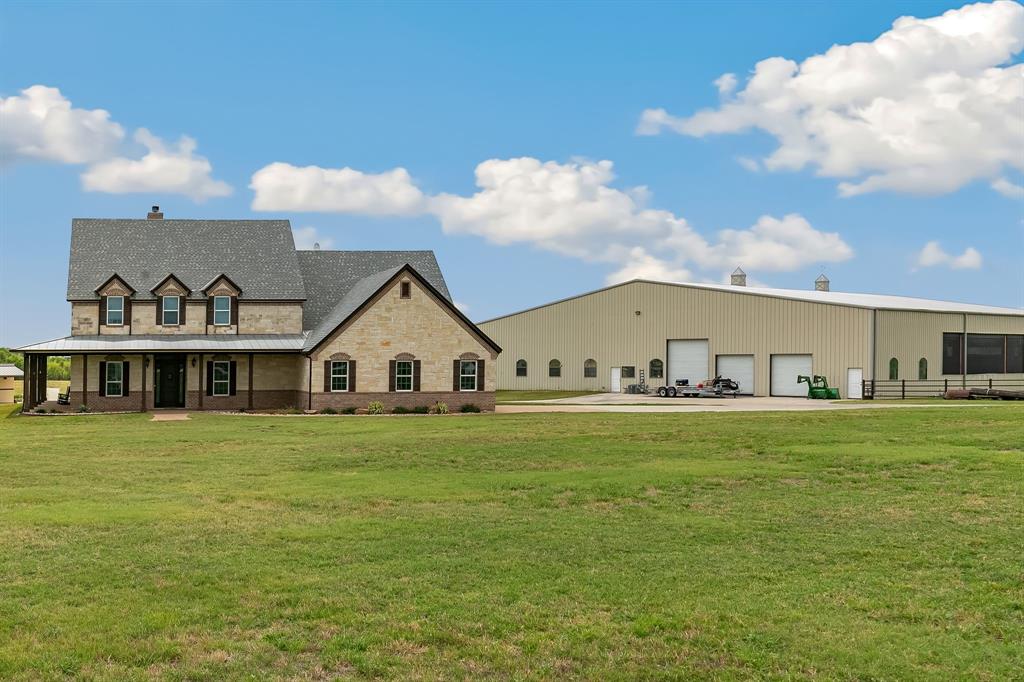 a view of a big house with a big yard and large trees