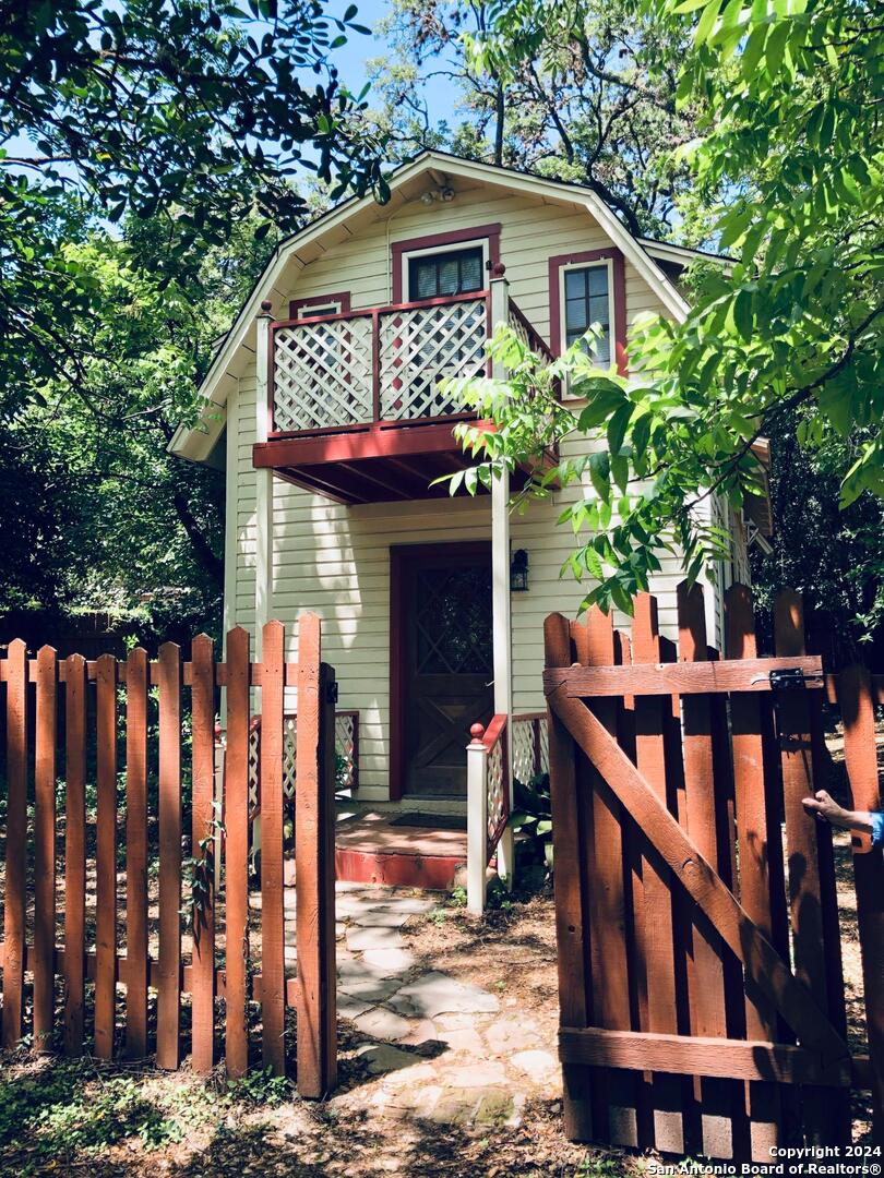 a front view of house with yard and trees in the background