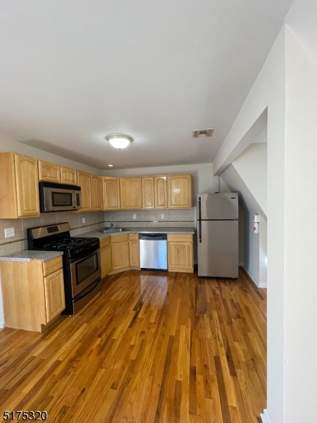 a large kitchen with cabinets and stainless steel appliances