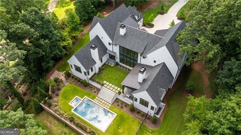 an aerial view of residential house with outdoor space and trees all around