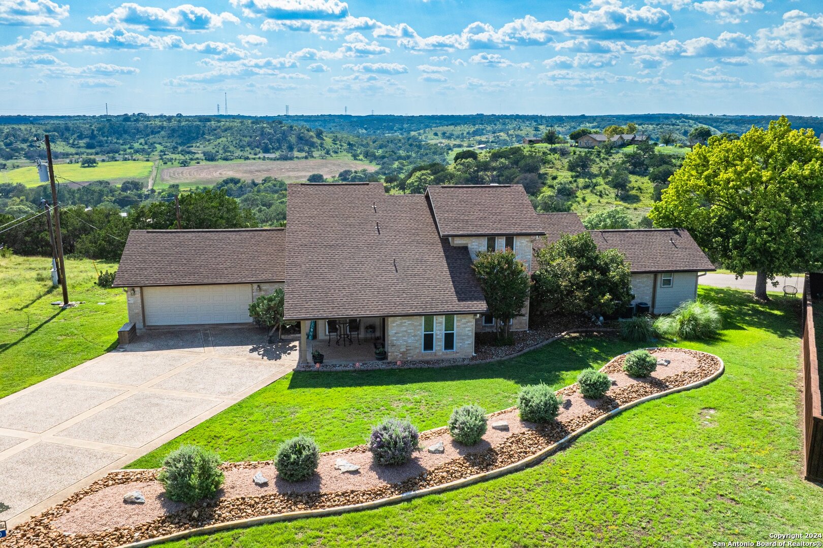 an aerial view of a house with swimming pool big yard and large tree