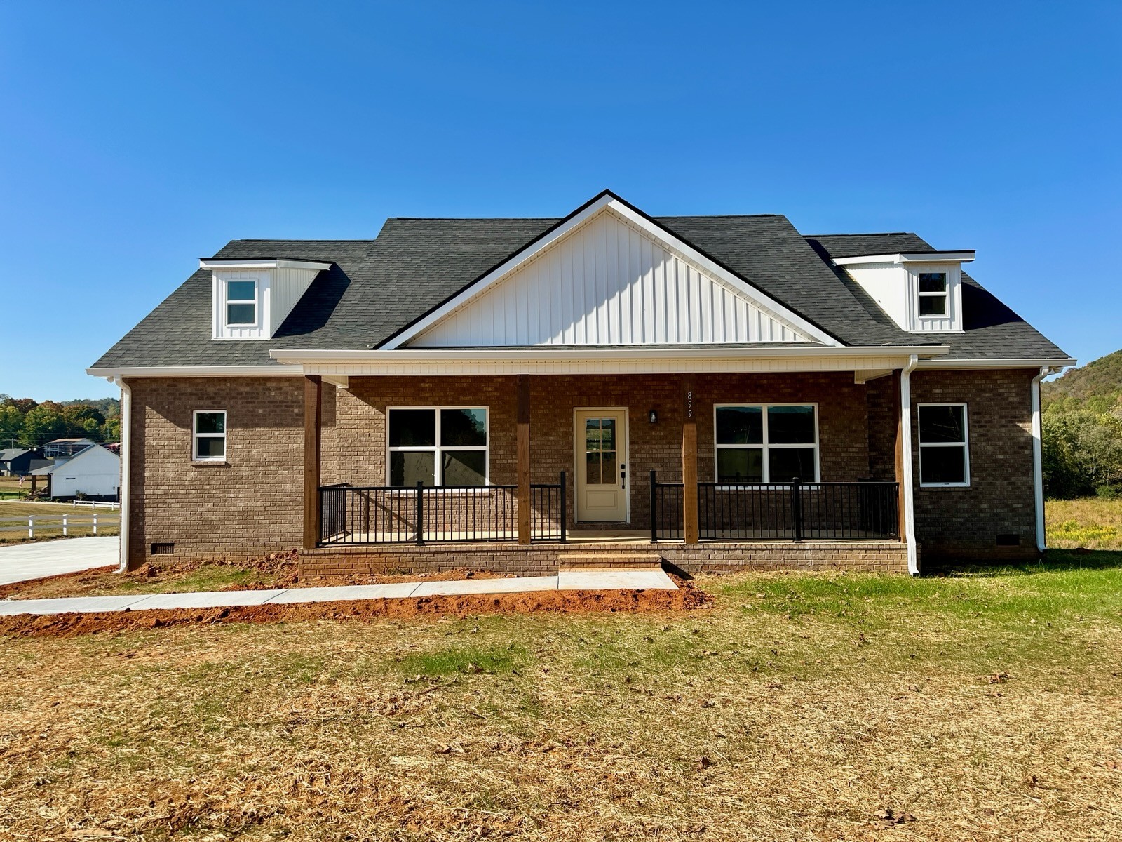 a front view of a house with a garden and yard