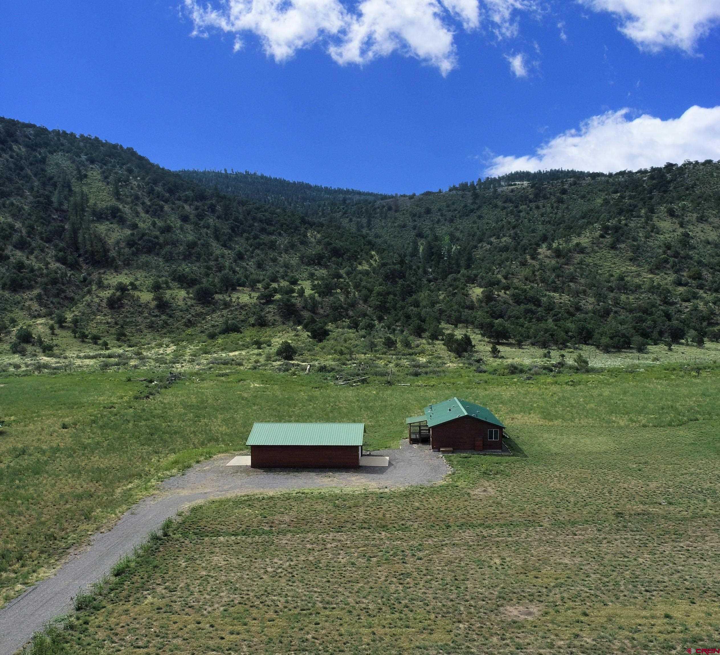 a view of a green field with mountain in the background