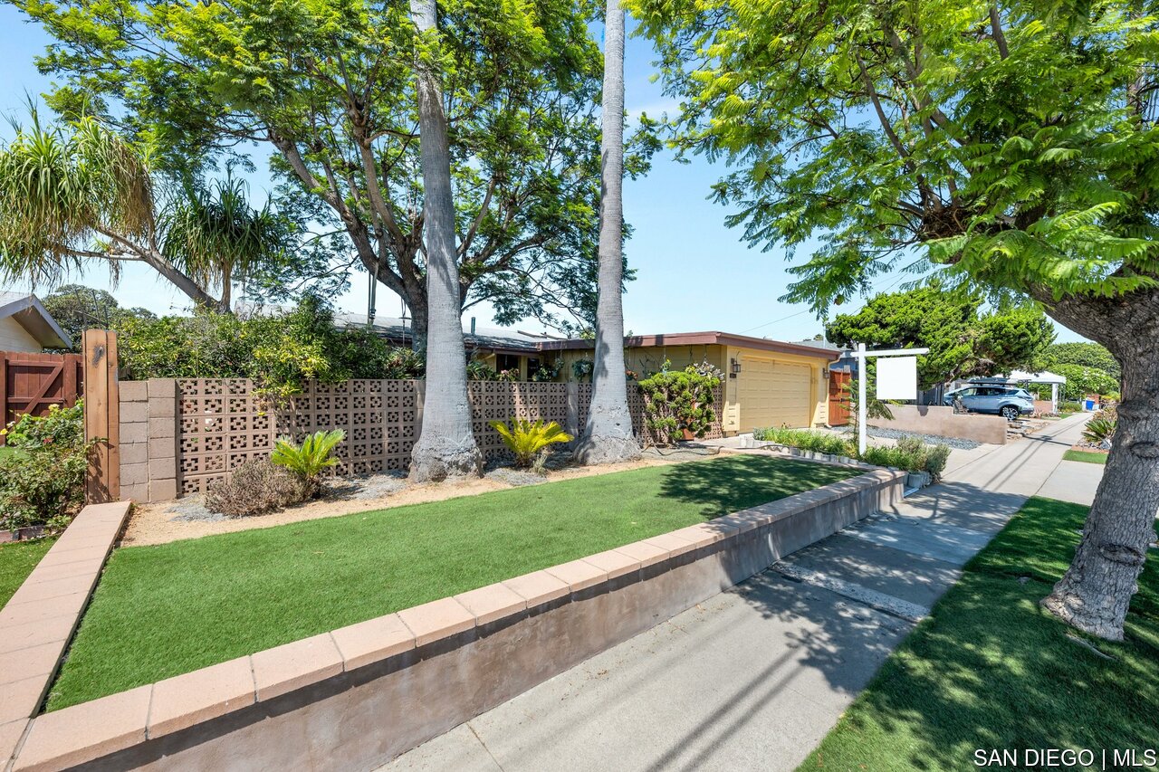 a view of a house with backyard and a tree